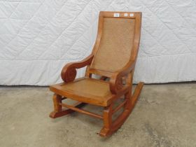 Late 20th century hardwood childs rocking chair with varnished rattan seat and back Please note