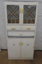 White painted vintage kitchen cabinet with two glazed doors, two drawers, pull out enamel top tray/