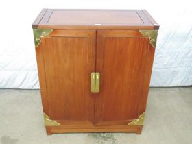 Hardwood drinks cabinet with brass embellishments having lift up top over two doors opening to