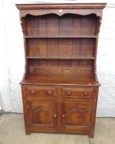 Oak dresser with two plate racks to upper section over two short drawers and two cupboard doors with