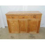 Victorian pine dresser base having three drawers over three doors opening to reveal single shelf,