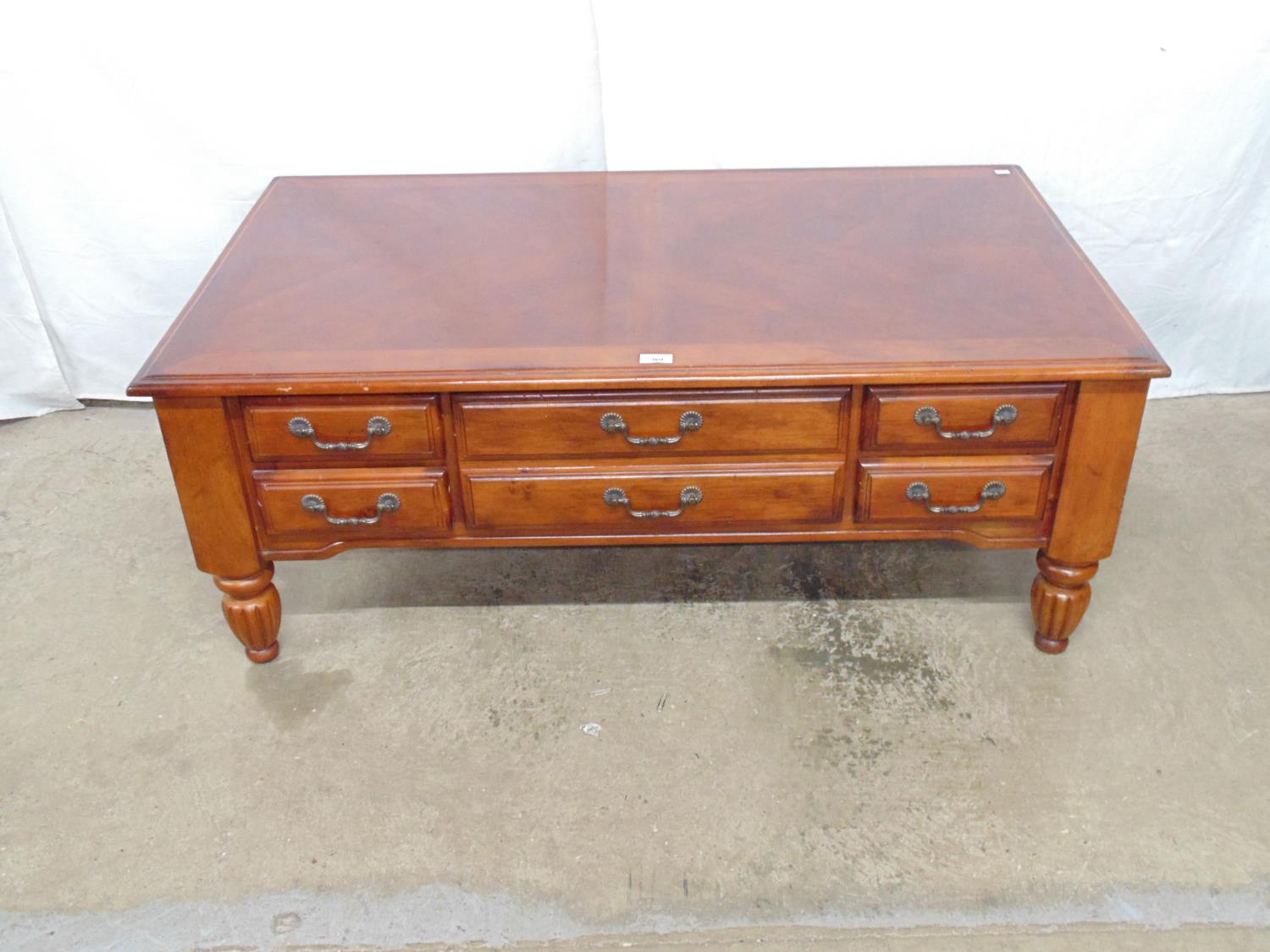 Modern coffee table with five drawers (simulating six) to one side, standing on bulbous reeded