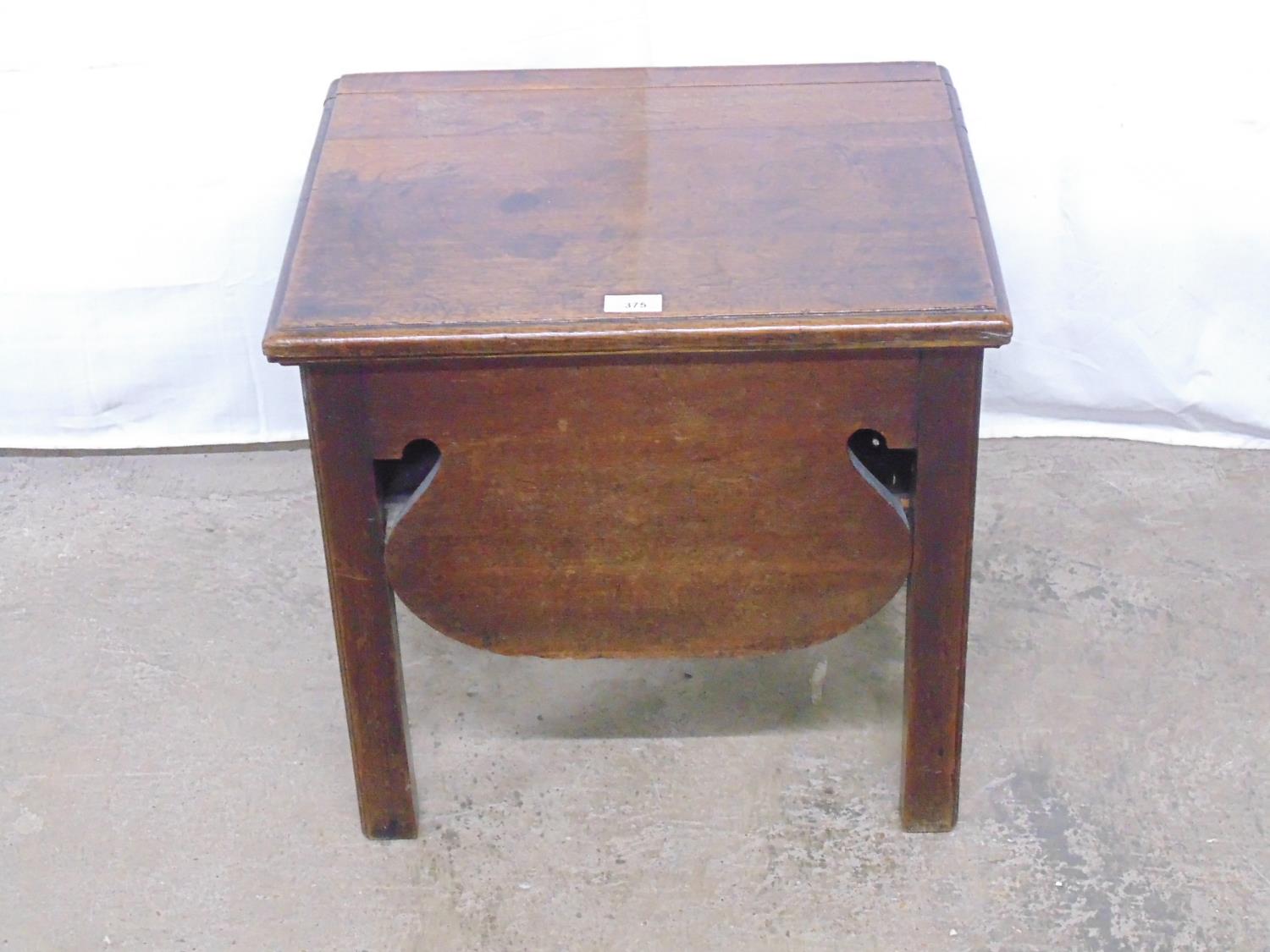 Oak commode having lift up top opening to reveal storage space with shaped sides, standing on square