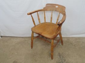 Elm Captains chair having turned spindles and standing on turned stretchered legs Please note