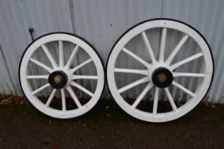 Two painted wooden cart wheels with iron rims and brass hub nuts - 31.5" and 35.5" dia Please note