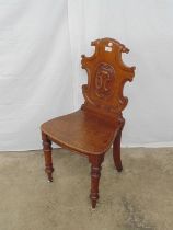 Oak hall chair with carved and shape back over solid seat, standing on turned legs Please note