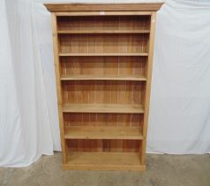 Pine bookcase with one fixed and four adjustable shelves, standing on plinth base - 44.25" x 12.5" x