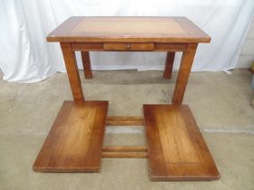 Late 20th century rustic oak dining table with single drawer and two leaves, standing on square legs