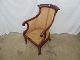 Victorian mahogany bergere armchair with turned front legs and shaped back legs, all on castors -