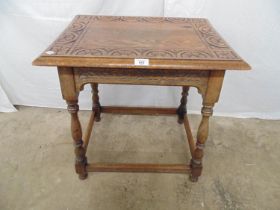 Oak occasional table with carved top and frieze, standing on turned stretchered legs - 24.25" x