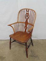 19th century yew wood Windsor chair having spindle and wheelback, standing on turned stretchered