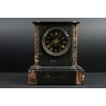 An antique french slate mantle clock with marble decoration and black dial.