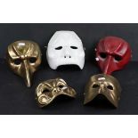 A collection of five wall hanging face masks.