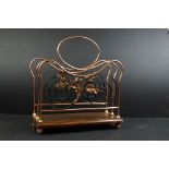 A copper and wrought iron magazine rack with foliate decoration.