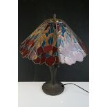 Tiffany style table lamp, with stained glass shade in red, salmon pink and blue, above a metal