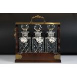 Early 20th Century mahogany & brass three bottle tantalus with brass mounts & carry handle, three