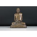 Bronze figure of a praying Buddhist Monk seated in a cross legged pose with hands together,