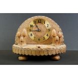 Carved burr wood toadstool clock with Arabic numerals on a brass dial, cog-like carved edge rims,