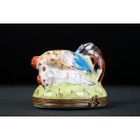 An decorative enamel trinket box in the form of a chicken and cockerel.