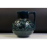 Blue glazed iridescent jug with relief decoration of flowers in a basket, of globular form, approx