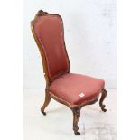 Victorian Walnut Framed High Back Nursing Chair with carved scroll frame and raised on castors, 50cm