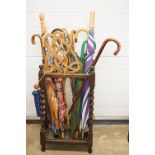 A large mixed collection of walking sticks, umbrellas and shooting stick contained within a wooden