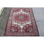 Eastern Red and Cream Ground Wool Rug with geometric stylised decoration, 190cm x 132cm