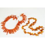 A vintage strung coral necklace together with a beaded amber example.