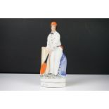 Staffordshire style figure of a batsman wearing an orange cap, a cream spotted shirt,