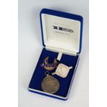 A small group of collectables to include a hallmarked silver motorcycling medal, coin brooch and