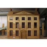 A very large kit built wooden dolls house together with a collection of dolls house furniture,