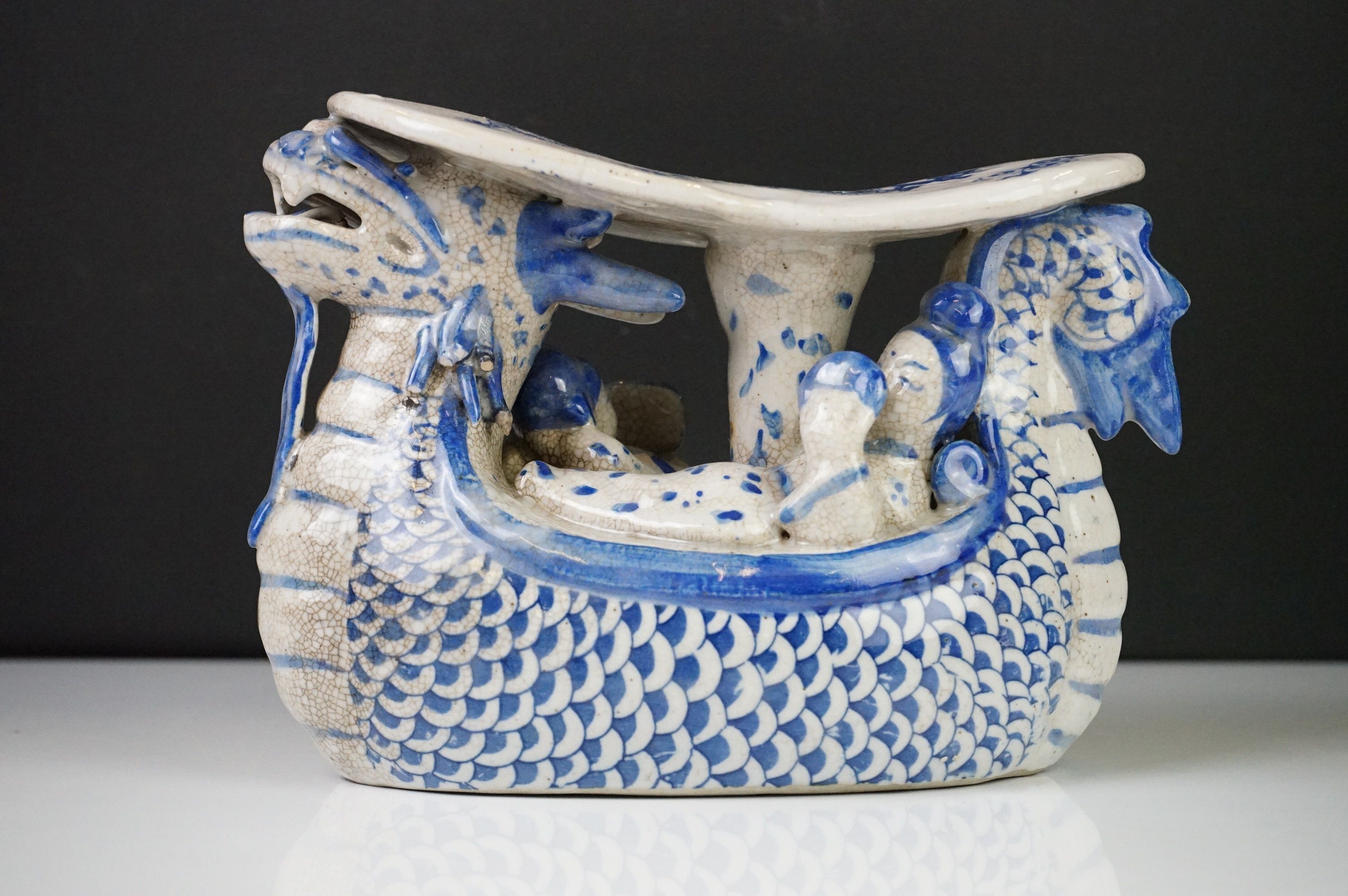 Chinese Blue and White Ceramic Head Rest in the form of a Dragon shaped Boat carrying figures,