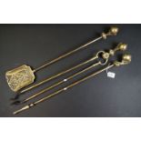 A set of three brass fire irons with decorative ball and claw handles.