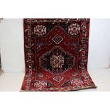 Eastern Red ground Wool Rug with geometric stylised pattern including birds, 148cm x 140cm