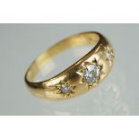 Diamond 18ct yellow gold three stone ring, three graduated round old cut diamonds, gypsy set, the