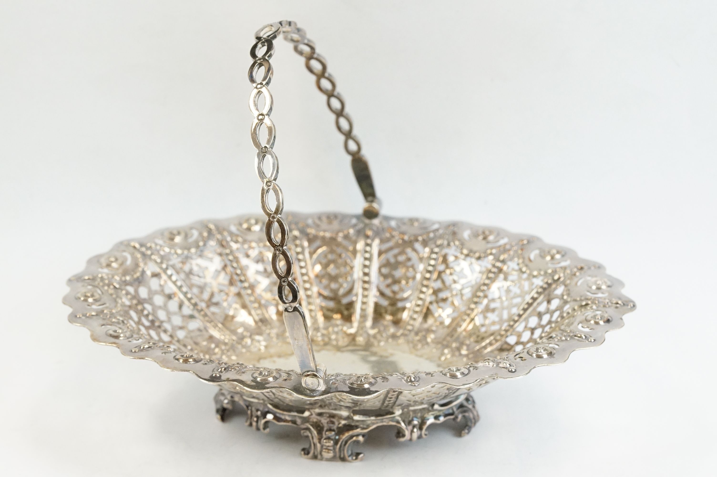 Victorian silver swing handled bon bon dish, pierced body, repoussé foliate and flower head