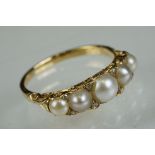 Pearl and diamond five stone yellow metal ring, five graduated split pearls, eight small rose cut