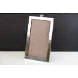 Large rectangular easel-back silver mounted photograph frame surmounted by a naval crown motif,