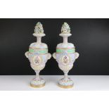 Pair of Continental Porcelain Urns with Covers each decorated with two oval panels of floral