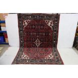 Eastern Wool Red Ground Rug with geometric pattern within a border, 200cm x 139cm