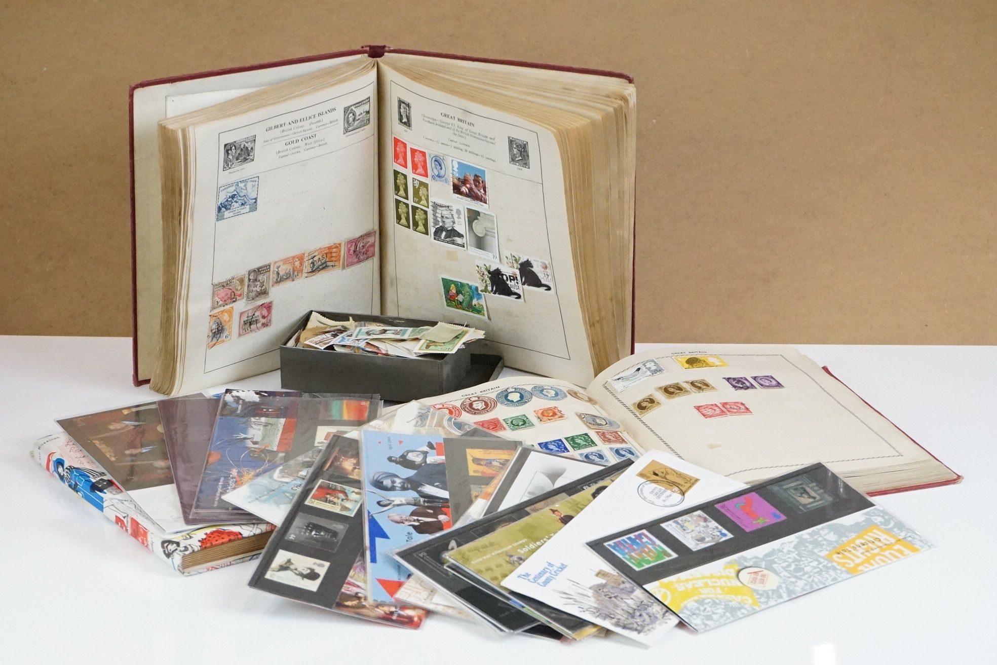 A small collection of British and world stamps contained within three albums together with a small