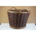 Wicker twin-handled log basket of tapering circular form, with loop handles. 54cm diameter x 43cm H