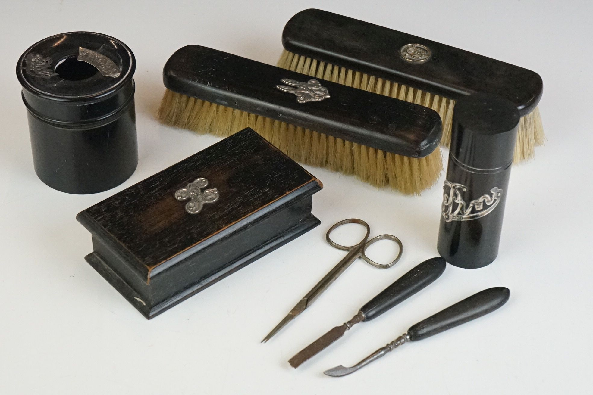 An early 20th century ebony brush set together with a group of other ebony items to include stud box