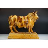 Slipware Wine Flask in the form of a Bull stood on a stepped plinth base, 37cm high x 39cm long