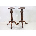 Pair of Hardwood Stands with circular tops over carved fluted columns and three splayed legs, 83cm