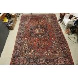 Large Eastern Wool Red Ground Rug with a geometric and floral pattern within a border, 240cm x 350cm