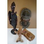 A collection of carved wooden ornaments to include a tribal mask and a large wooden figure...etc.