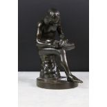 Bronze figure of a nude male seated on a tree stump, checking the sole of his foot, raised on a