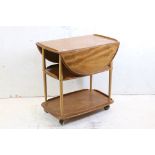 Ercol Elm and Beech Trolley, model no. 505, with an oval drop-leaf top and raised on swivel castors,