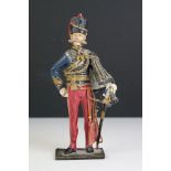 A decorative painted metal soldier in traditional uniform.